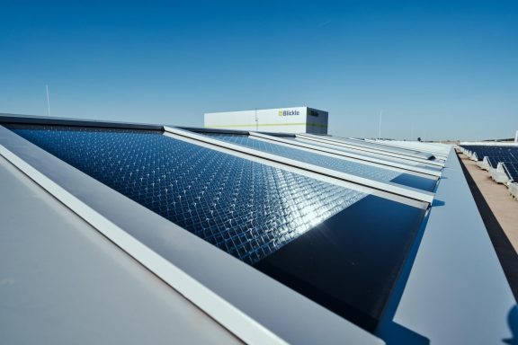 Solar panels on rooftops under a clear blue sky.