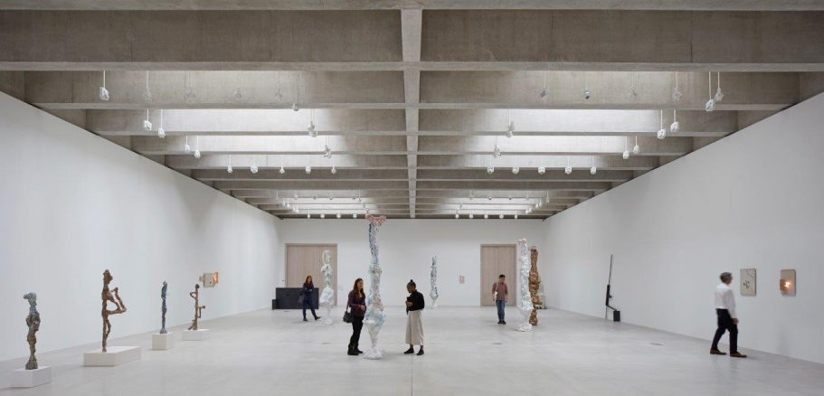 Tate St Ives (Internal), UK A spacious art gallery featuring sculptures, paintings, and visitors interacting.
