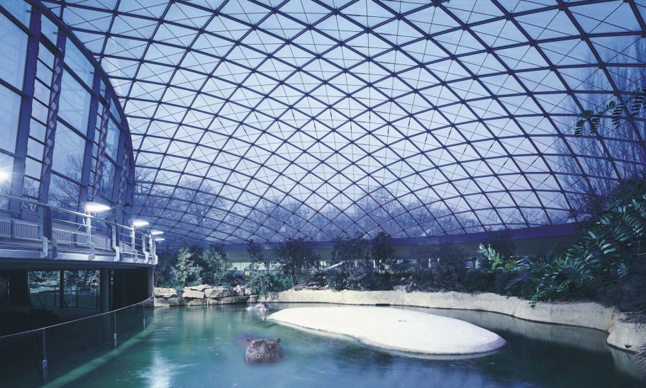 Hippo Bay, Berlin Zoo, Germany Interior of a modern dome structure with a water feature and tropical plants.