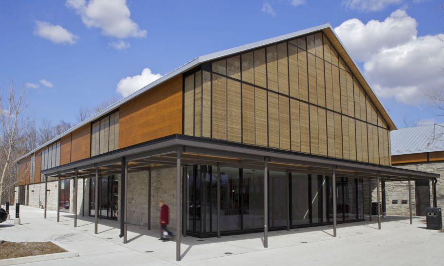 Community Centre & Library, Ontario Modern building with a wooden facade and large glass windows, situated in a landscaped area.