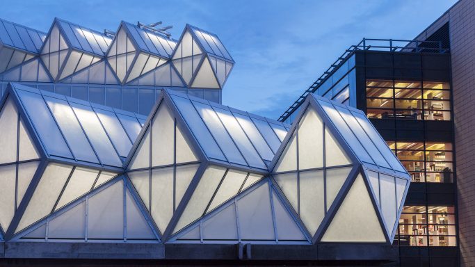 Modern architecture featuring geometric glass panels and a unique roof design.