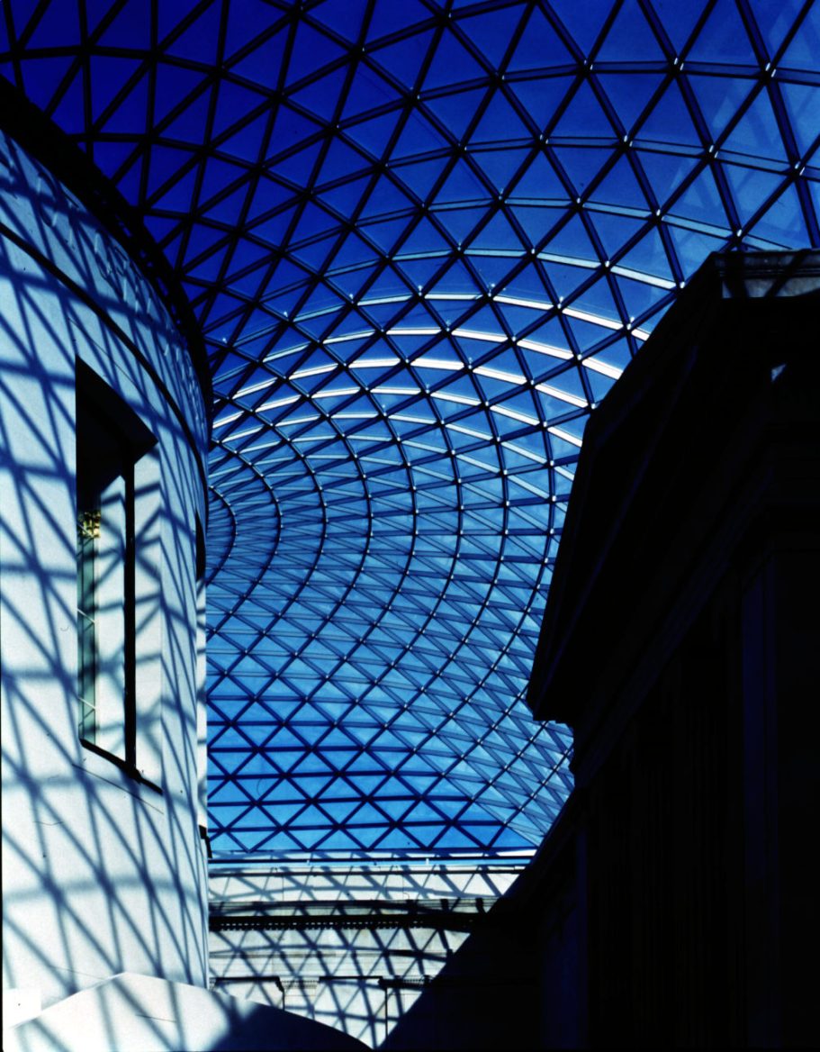 Great Court, The British Museum, London Geometric ceiling structure with blue sky and shadows cast on walls.