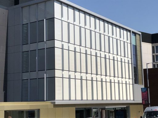 Modern building with large glass with expanded metal mesh windows and a sleek facade.